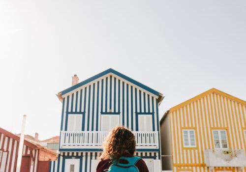 back view of backpacker woman in front of colorful houses aveiro